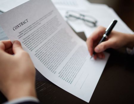 Close-up of male hands signing a contract with pen